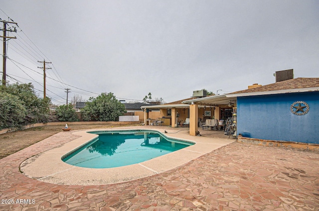 outdoor pool with central air condition unit and a patio