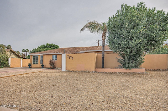 view of front of house with fence and stucco siding