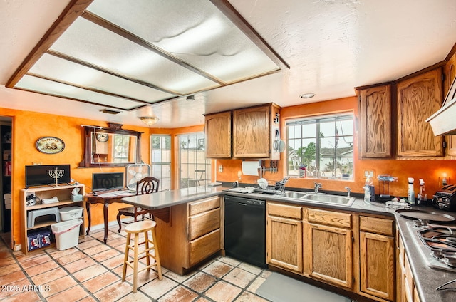 kitchen with brown cabinetry, a sink, dishwasher, and a peninsula