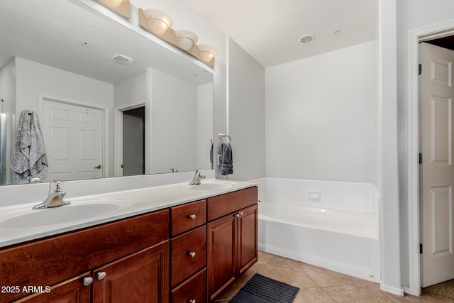 full bathroom with double vanity, tile patterned floors, a sink, and a bath