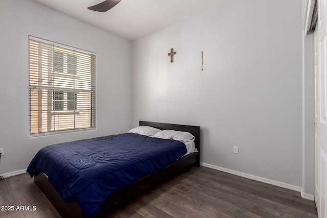 bedroom with baseboards, multiple windows, and wood finished floors