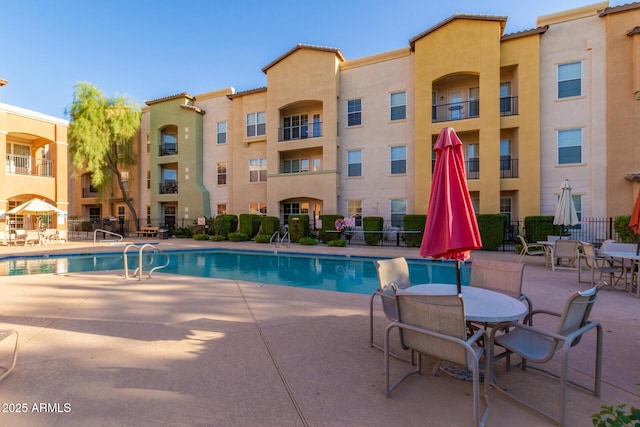 pool with a patio and fence