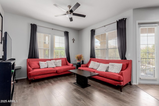 living room with baseboards, ceiling fan, and wood finished floors