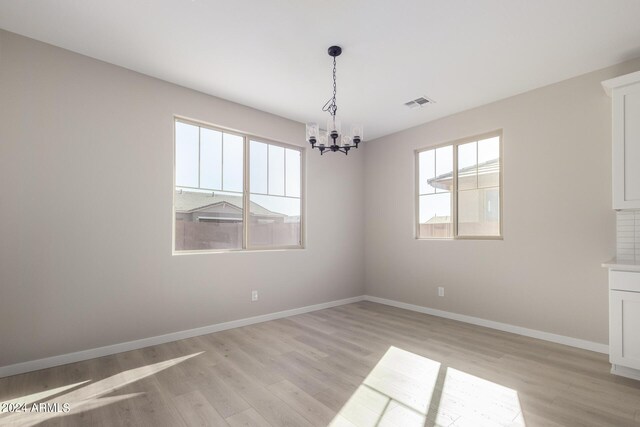 interior space with a notable chandelier and light hardwood / wood-style flooring