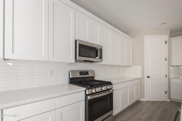 kitchen with appliances with stainless steel finishes, light hardwood / wood-style flooring, white cabinets, and decorative backsplash