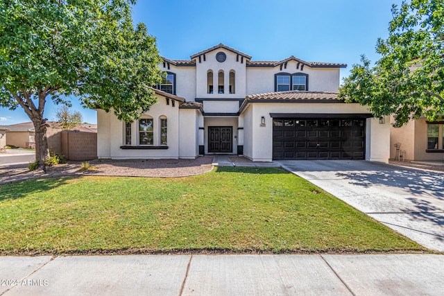 mediterranean / spanish-style house featuring a garage and a front lawn