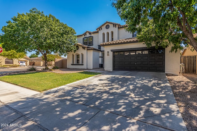 mediterranean / spanish-style home with a garage and a front lawn