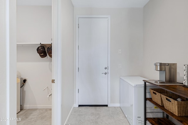 interior space with light tile patterned floors and baseboards