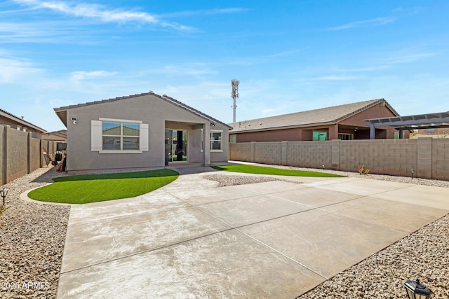 view of front of property with stucco siding, a patio area, a fenced backyard, and a pergola