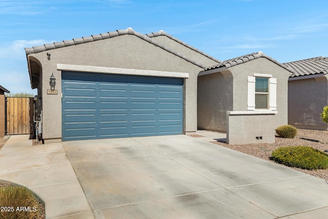 view of front of house with driveway, a tile roof, an attached garage, and stucco siding