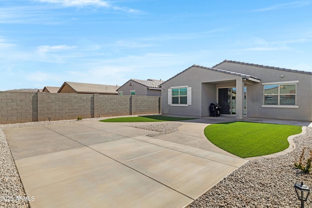 back of house featuring a patio area, a fenced backyard, a tile roof, and stucco siding