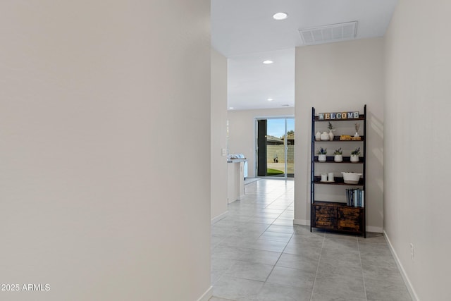 hall with light tile patterned flooring, baseboards, visible vents, and recessed lighting