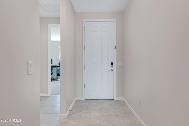 foyer featuring light tile patterned floors and baseboards