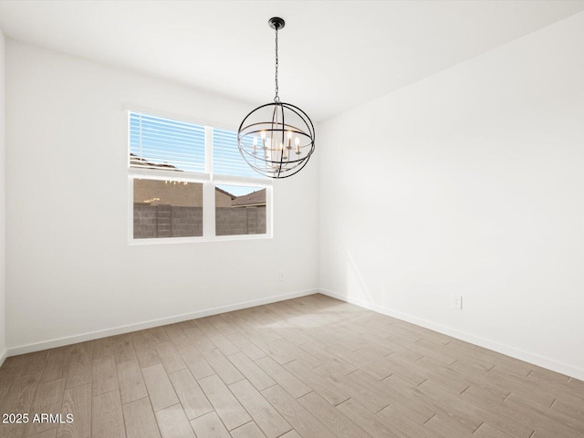 17703 W Southgate Ave, Goodyear, AZ 85338 - unfurnished room with a chandelier, baseboards, and wood finished floors