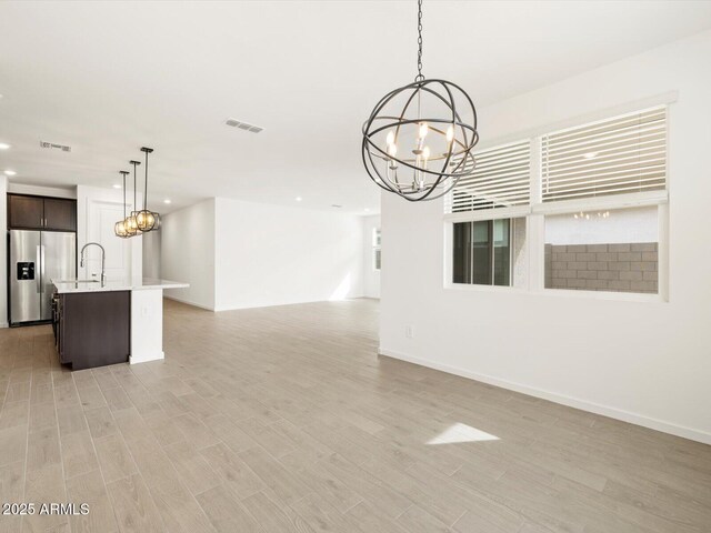 17703 W Southgate Ave, Goodyear, AZ 85338 - unfurnished living room with recessed lighting, an inviting chandelier, and light wood-style flooring