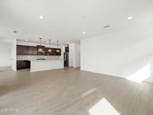 17703 W Southgate Ave, Goodyear, AZ 85338 - unfurnished living room with light wood finished floors, visible vents, and recessed lighting