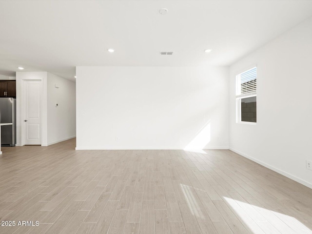 17703 W Southgate Ave, Goodyear, AZ 85338 - unfurnished living room featuring recessed lighting, visible vents, baseboards, and light wood-style flooring