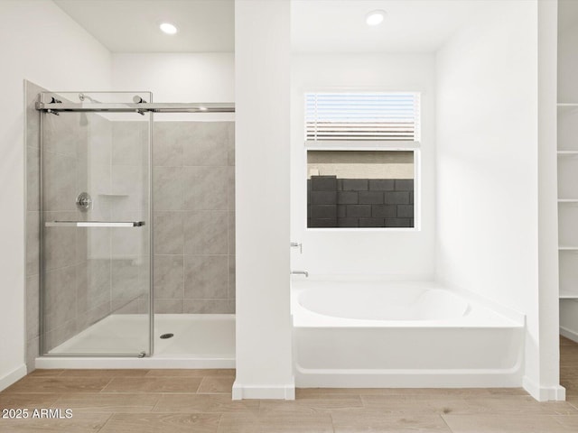 17703 W Southgate Ave, Goodyear, AZ 85338 - bathroom featuring wood finish floors, a bath, and a shower stall