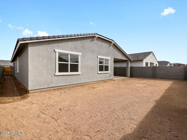 17703 W Southgate Ave, Goodyear, AZ 85338 - rear view of property featuring a tile roof, a fenced backyard, and stucco siding