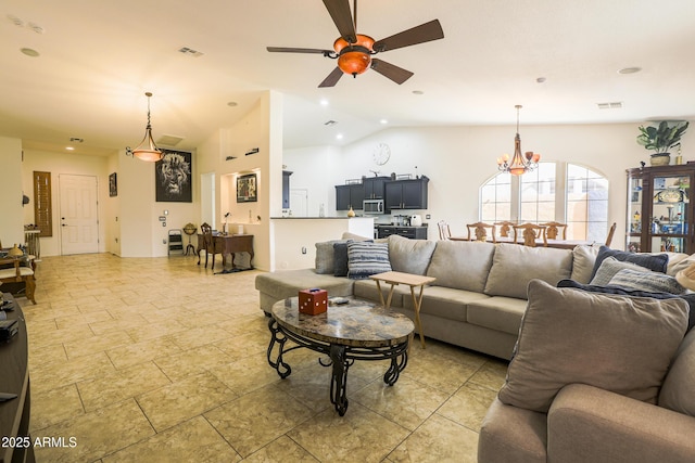 living area featuring recessed lighting, visible vents, vaulted ceiling, and ceiling fan with notable chandelier