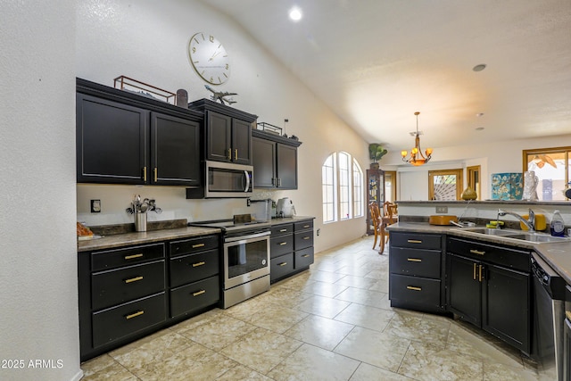 kitchen with stainless steel appliances, a healthy amount of sunlight, a sink, and a notable chandelier