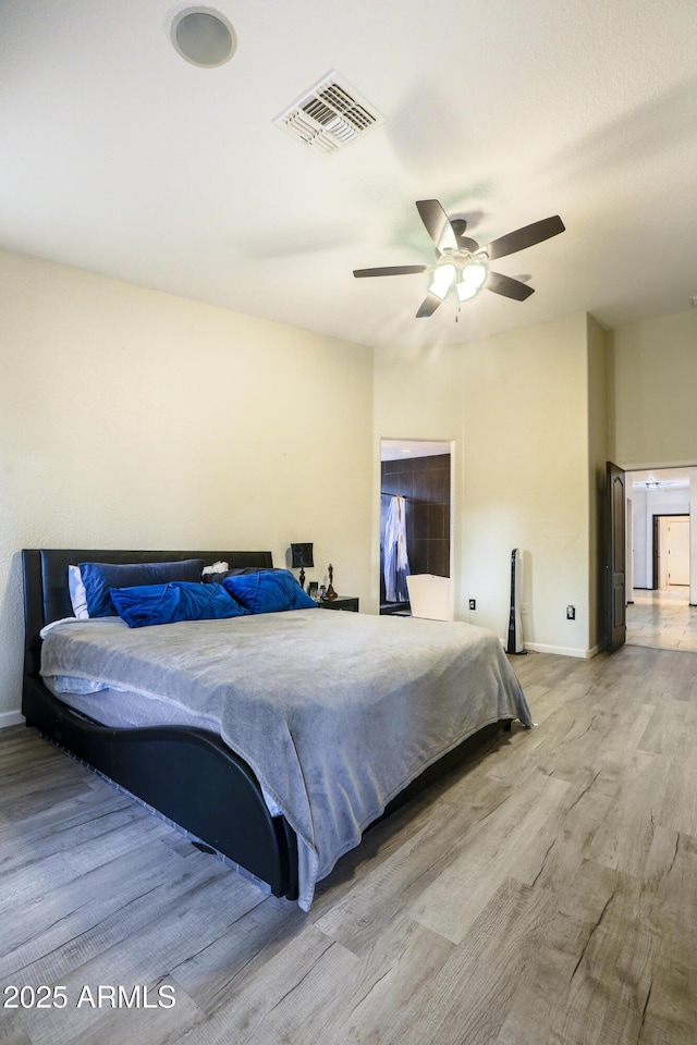 bedroom featuring a ceiling fan, baseboards, visible vents, and wood finished floors