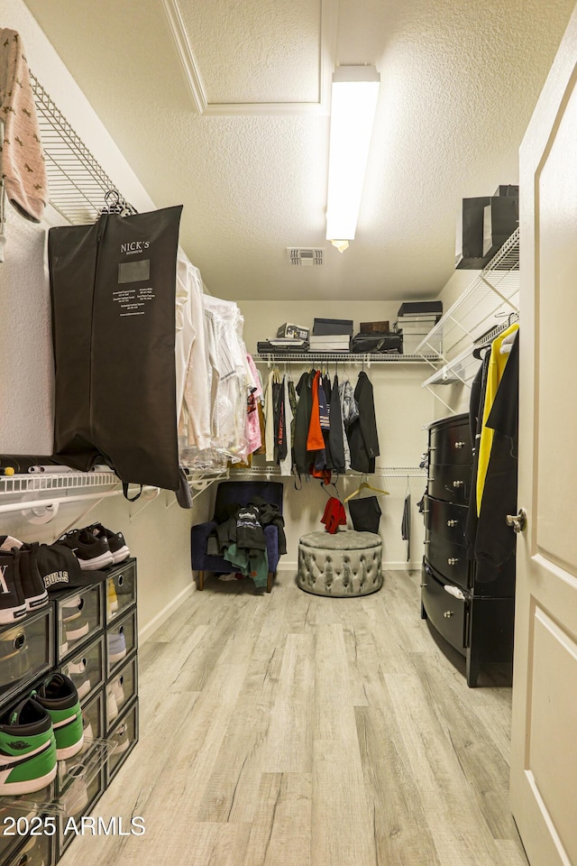 walk in closet featuring wood finished floors and visible vents