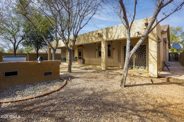 back of house featuring a patio area, fence, and stucco siding