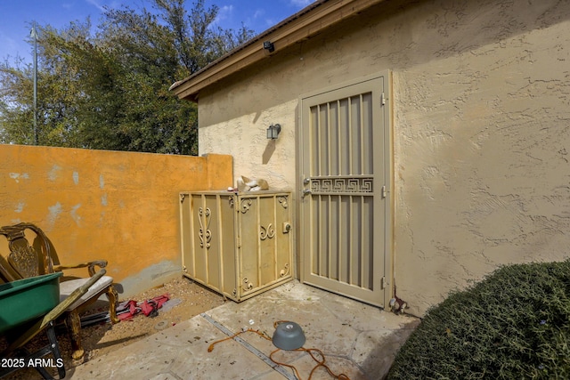 view of side of property featuring fence and stucco siding