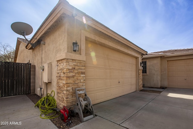 garage with fence and concrete driveway