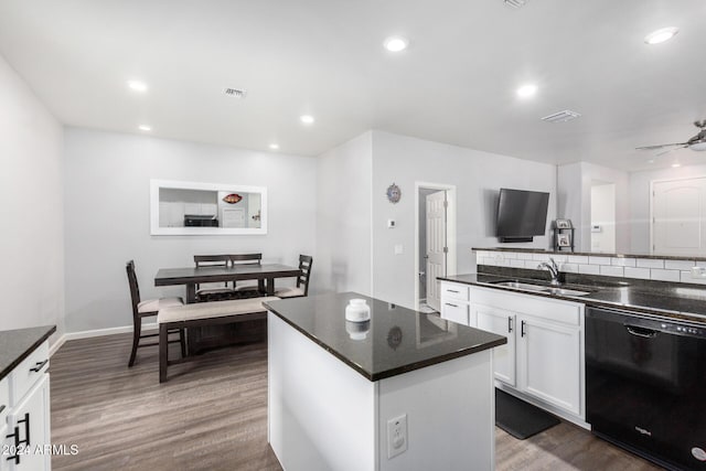 kitchen with dark wood-type flooring, sink, dishwasher, a center island, and white cabinetry