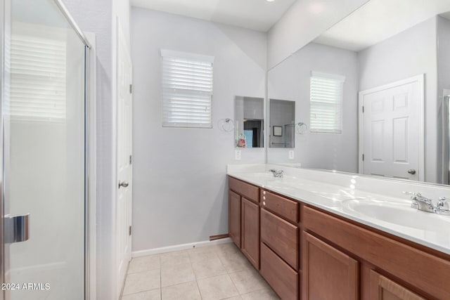 bathroom featuring a shower with door, vanity, and tile patterned flooring