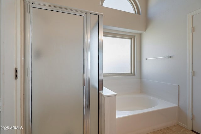 bathroom featuring plenty of natural light and independent shower and bath