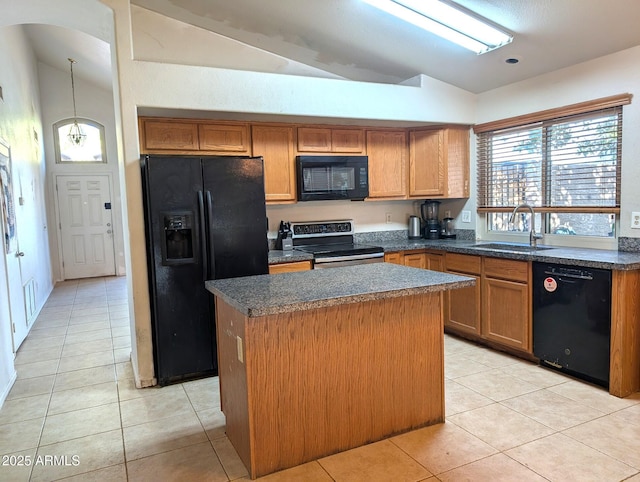 kitchen featuring lofted ceiling, sink, light tile patterned floors, a kitchen island, and black appliances