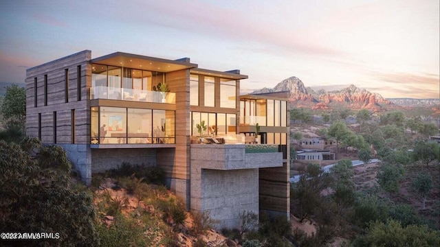 back of property at dusk with a balcony