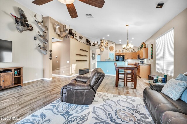 21604 E Calle De Flores, Queen Creek, AZ 85142 - living area featuring vaulted ceiling, light wood-type flooring, ceiling fan with notable chandelier, baseboards, and visible vents