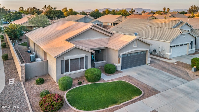 21604 E Calle De Flores, Queen Creek, AZ 85142 - view of front of property featuring concrete driveway, stucco siding, fence, a garage, and central AC