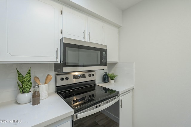 kitchen with white cabinets, backsplash, stainless steel appliances, and hardwood / wood-style floors