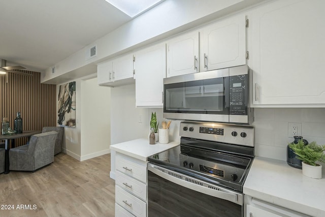 kitchen featuring decorative backsplash, appliances with stainless steel finishes, light wood-type flooring, and white cabinetry