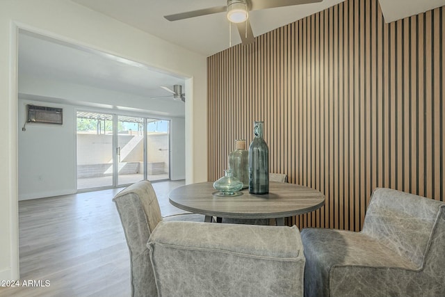 dining room featuring a wall mounted air conditioner and light hardwood / wood-style floors