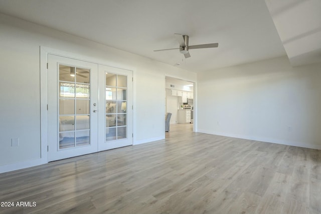 unfurnished living room with ceiling fan, french doors, and light hardwood / wood-style floors