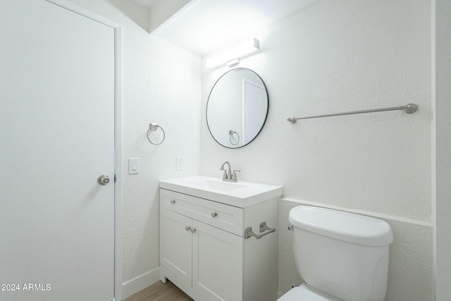 bathroom with hardwood / wood-style floors, vanity, and toilet