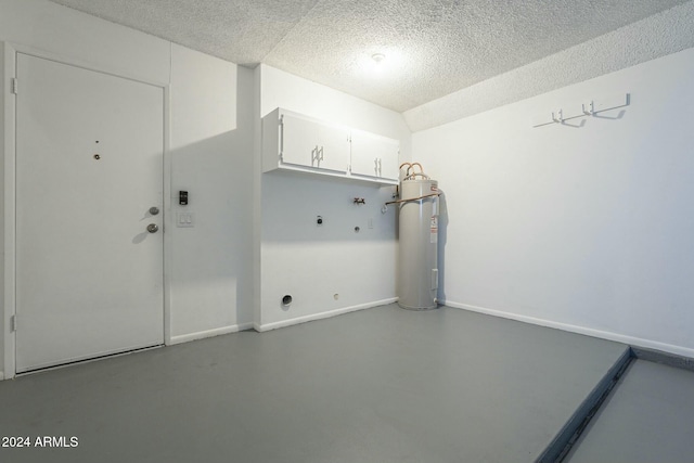 washroom featuring cabinets, hookup for a washing machine, a textured ceiling, electric dryer hookup, and water heater