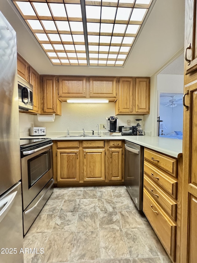 10330 W Thunderbird Blvd Unit C206, Sun City, AZ 85351 - kitchen with appliances with stainless steel finishes, light countertops, brown cabinets, and stone finish floors