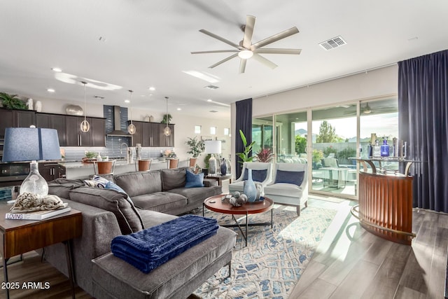 living area featuring visible vents, recessed lighting, a ceiling fan, and wood finished floors