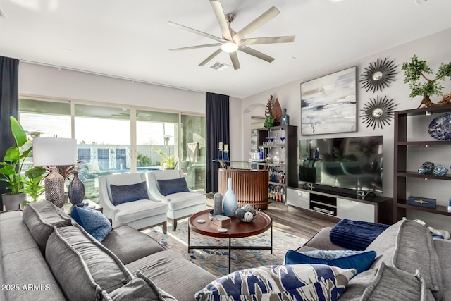 living area with wood finished floors, ceiling fan, and visible vents