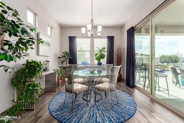 dining space with wood finished floors and a chandelier