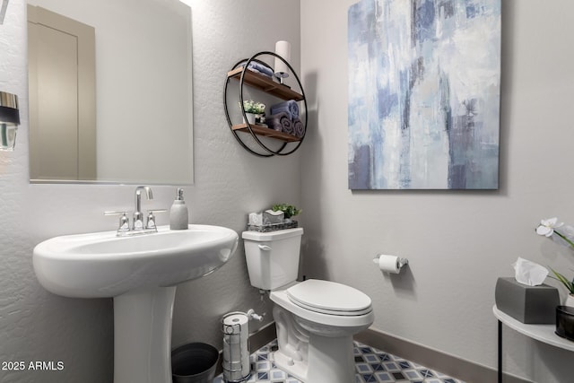 bathroom with baseboards and toilet