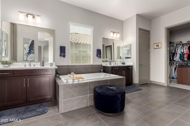 full bath with a bath, a sink, and tile patterned flooring