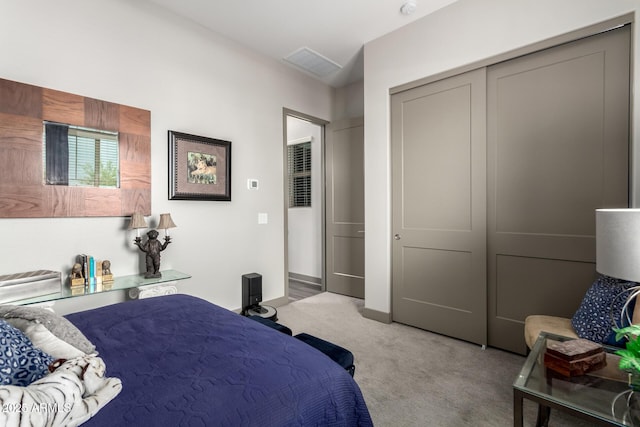 bedroom with light carpet, a closet, and visible vents